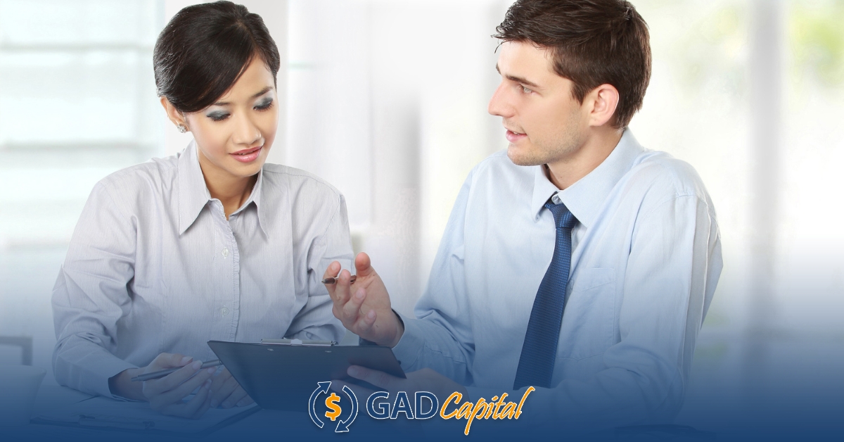 A man and woman sitting at a table with a tablet reading about Idaho installment loans