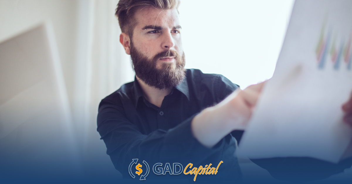 A man with a beard holding a piece of paper reading about title loans in Washington